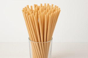 Glass of beige biodegradable straws on table