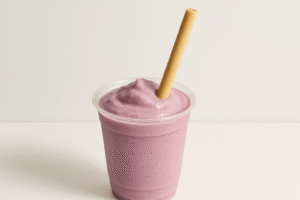 Purple smoothie in cup with straw